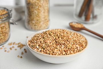 Uncooked green buckwheat grains on white table
