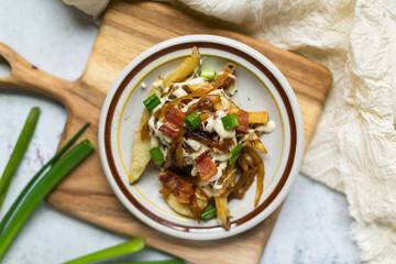 French fries topped with bacon, grilled onions, chives, and remoulade sauce