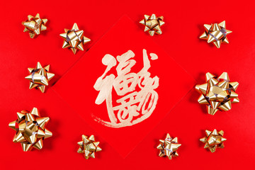 Chinese lunar New Year Blessing for luck and happiness with golden gift bows on the red background. Traditional celebration concept