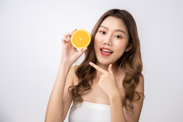 Beautiful Young Asian Woman short hair  with Clean Fresh Skin. Face care, Facial treatment, Cosmetology, beauty and healthy skin and cosmetic ideas concept.pretty woman holding half of orange .