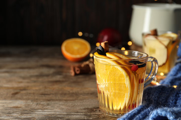Aromatic mulled wine on wooden table. Space for text