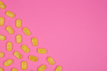 Many delicious lemon drops on pink background, flat lay. Space for text