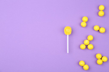 Different lemon candies on purple background, top view. Space for text