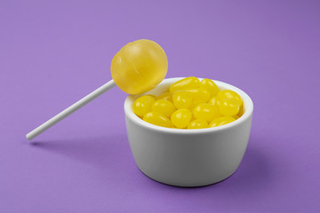 Different lemon flavored candies on purple background