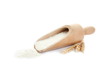 Organic flour, wooden scoop and spikelets isolated on white