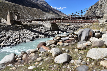 インドのヒマラヤ山岳地帯　スピティ谷の絶景　美しい山と渓谷と青空　雪解け水の川と吊り橋