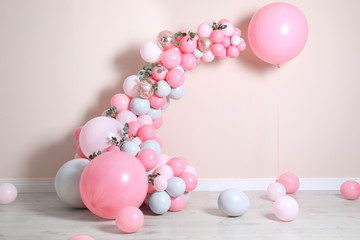 Beautiful composition with balloons near beige wall