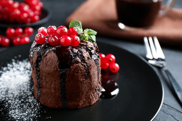 Delicious warm chocolate lava cake with mint and berries on table, closeup