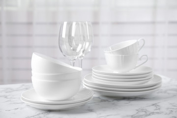Set of clean tableware on white marble table