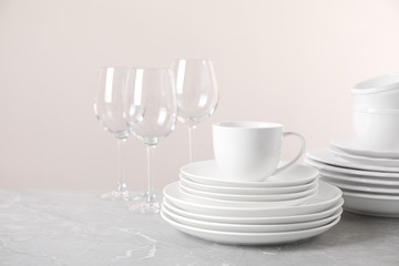 Set of clean tableware on light grey marble table