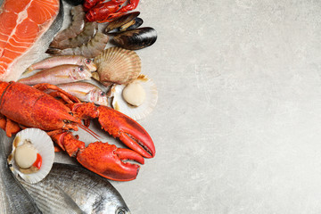 Fresh fish and seafood on marble table, flat lay. Space for text