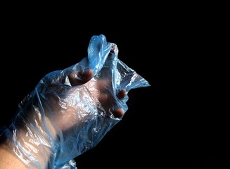 Hand with plastic bag on black background. pollution concept