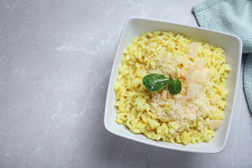 Delicious risotto with cheese on grey marble table, top view. Space for text