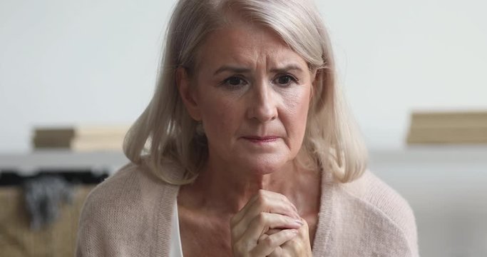 Thoughtful worried older lady concerned about health problems at home