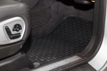 Clean car floor mats of black rubber under passenger seat in the workshop for the detailing vehicle...