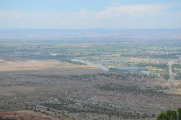 Fototapeta na wymiar Early Summer in Colorado: Looking North From Colorado National Monument to the Colorado River, City of Fruita, the Grand Valley and the Book Cliffs