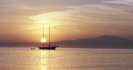 Fototapeta na wymiar sunrise on the sea with sailboat
