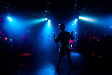 Fototapeta na wymiar artist with a microphone performs on the stage of a nightclub