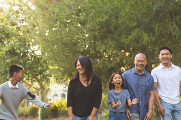 Happy Asian family walking and talking outside. - Powered by Adobe