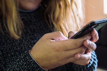 Mujer rubia envía mensajes en celular
