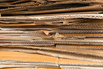 Close up of wavy brown paper box stacking in layers. Concept of recycle paper texture, shipping and logistic industry, packaging business, card, carton and production.