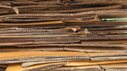 Close up of wavy brown paper box stacking in layers. Concept of recycle paper texture, shipping and logistic industry, packaging business, card, carton and production.
