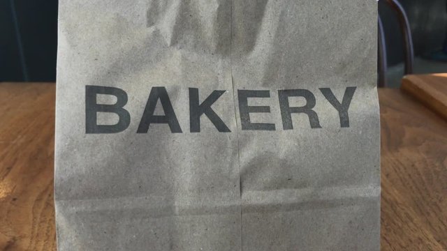 Camera tracking left to right on paper bag with the word bakery printed on it