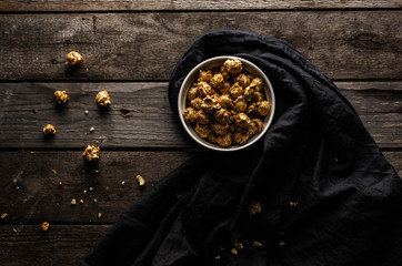 popcorn in a bowl, sweet popcorn, sweet snack, dessert, popcorn on a wooden background, crumbs from dessert