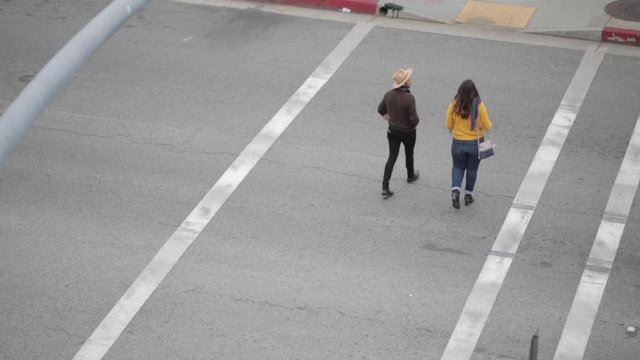 Trendy urban Hipster Couple on a date crossing street on cloudy day in downtown los angeles old colorado road pasadena california