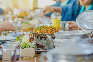 Group of female friends enjoy eating with acacia pennata omelette sour soup in fish shape hot pot in the restaurant. Selective focus.
