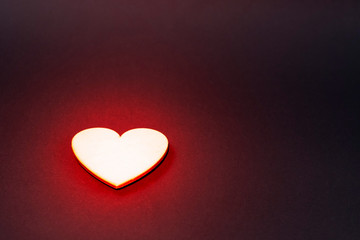 Sparkling golden heart on a dark background. Red backlight