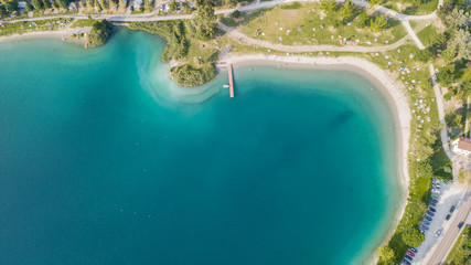 Up and down drone aerial view of the lake Ledro. A natural alpine lake. Amazing turquoise, green and blue natural colors. Italian Alps. Italy. Touristic destination. Summer time