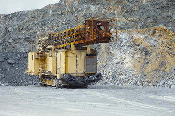 Drilling rig in transport position standing inside the quarry close-up.