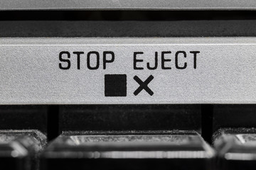 Macro close up photograph of vintage boombox stop and eject button detail.