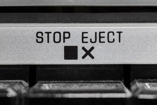 Macro close up photograph of vintage boombox stop and eject button detail.