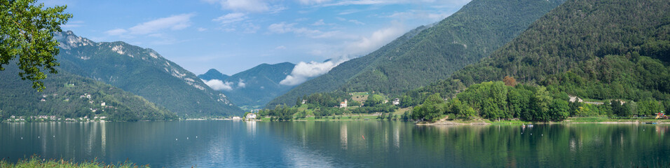 Fototapeta na wymiar Ledro, Italy. The Ledro lake is a natural alpine lake. Amazing turquoise, green and blue colors. Italian Alps. Touristic destination. Summer time