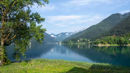 Fototapeta na wymiar Ledro, Italy. The Ledro lake is a natural alpine lake. Amazing turquoise, green and blue colors. Italian Alps. Touristic destination. Summer time