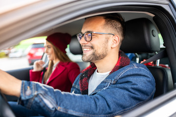 A young male and a young female in a car, window-shot.