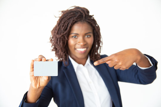 Content Businesswoman Pointing At Card. Cheerful Young African American Woman Holding Blank Business Card And Smiling At Camera. Business Concept