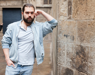 Fototapeta premium Handsome adult man with a beard in a jeans jacket
