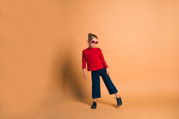 Fototapeta na wymiar cute trendy 7 years old girl posing in fashion clothes on color background