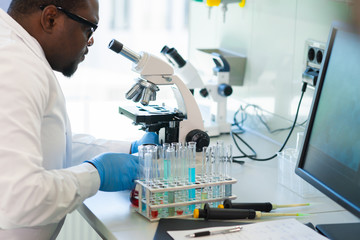 African-american scientist working in lab. Doctor making microbiology research. Laboratory tools:...