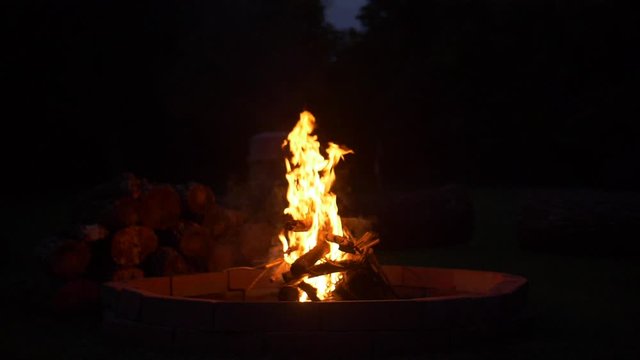 Slow motion camp fire burning at night.