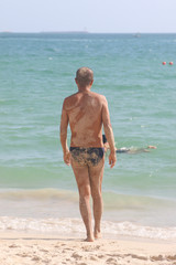 Fototapeta na wymiar man on the background of the sea in the sand