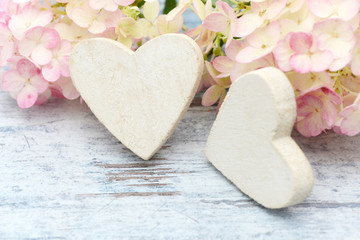 Fototapeta na wymiar flower and wooden white heart lying on wood