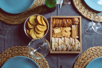 Different bread toast on a box on a served dining table with blue plates and fabrics