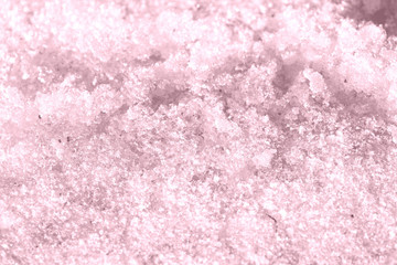 Spring snow texture close up. Abstract winter background pink color toned