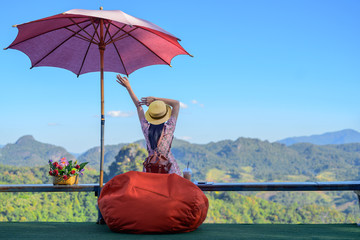 woman traveller sitting on terrace of the cafe enjoy scenery view of the Mountain at Countryside, cheeryfully life traveling