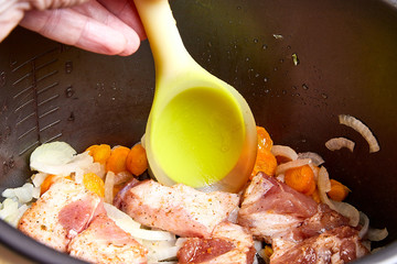 Cooking. Roasting pieces of meat with carrots or onions in a multicooker bowl