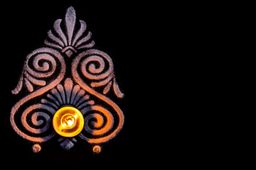 top view of awesome tea lamp and white color rangoli art on balck background with copy space. deepawali concept